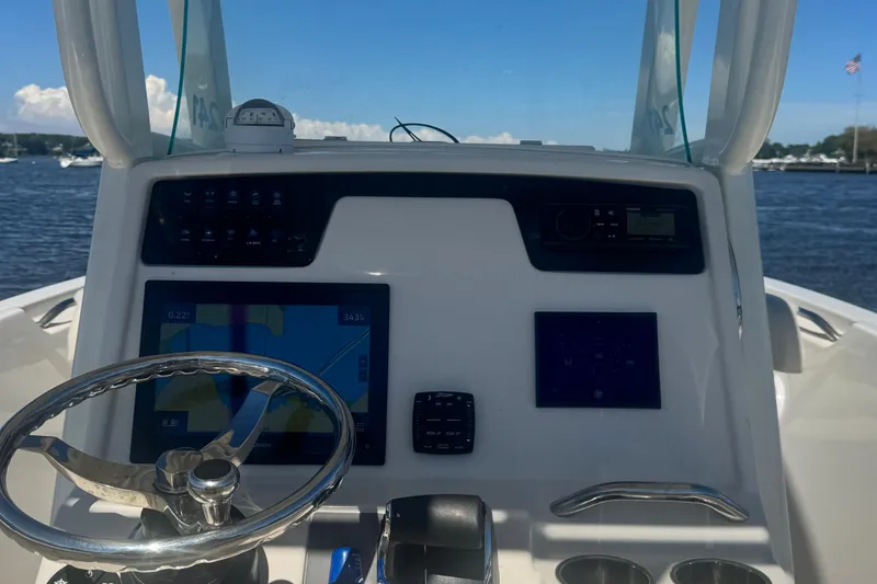 Slide: The Image of 2024 Sailfish 241 CC boat dashboard with navigation screens and steering wheel. - 11