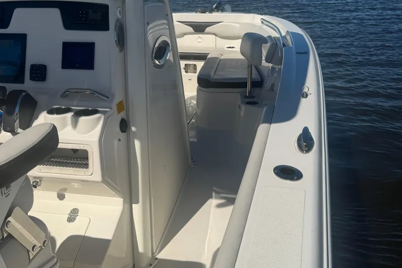 Slide: The Image of 2024 Sailfish 241 CC boat interior with seating and control panel by the water. - 12