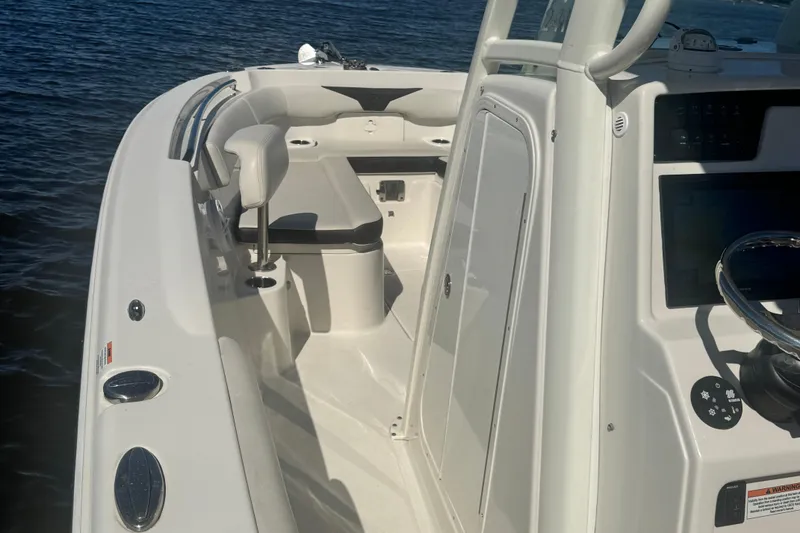 Slide: The Image of 2024 Sailfish 241 CC boat interior with seating and steering console on water. - 13