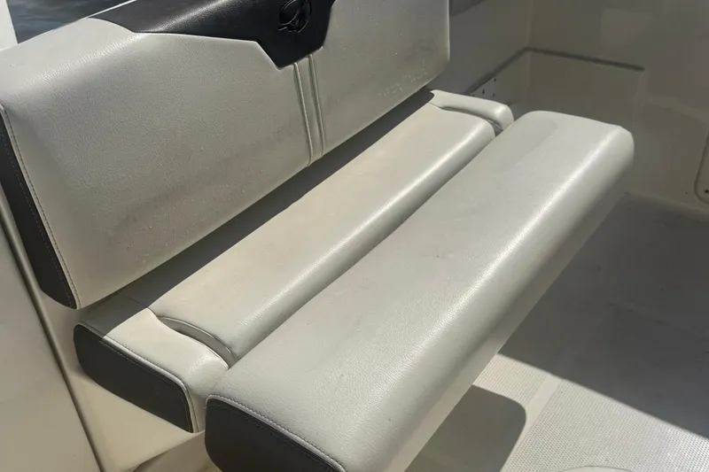 Slide: The Image of 2024 Sailfish 241 CC boat seat, featuring cushioned white and black upholstery. - 19
