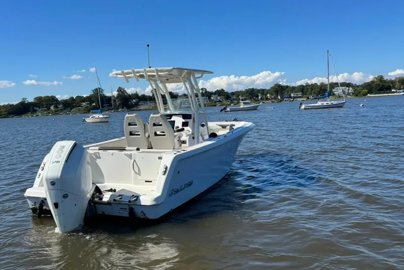 Slide: The Image of 2024 Sailfish 241 CC boat on calm water with other boats in the background. - 3