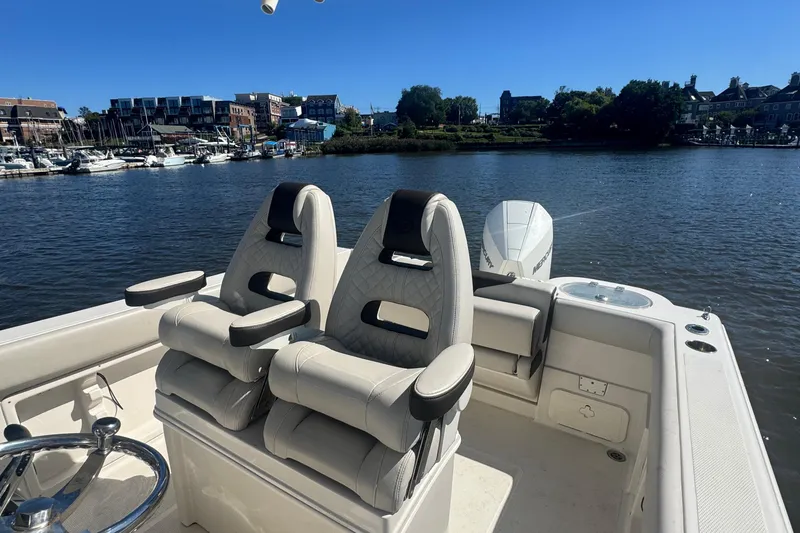 Slide: The Image of 2024 Sailfish 241 CC boat interior with dual seats on a calm river. - 7