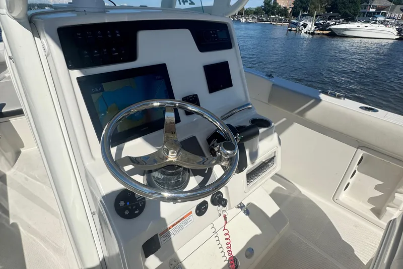 Slide: The Image of 2024 Sailfish 241 CC boat helm with steering wheel and navigation display. - 8