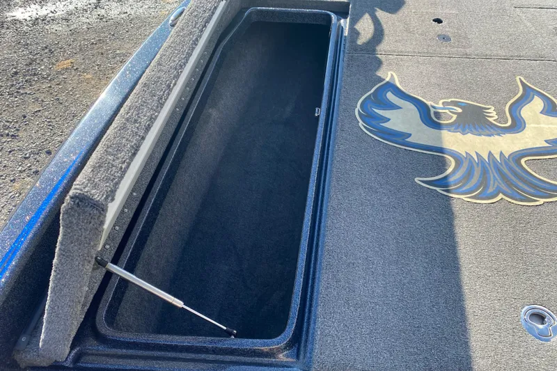 Slide: The Image of Open storage compartment on 2022 Phoenix 920 Elite boat with decorative eagle emblem. - 14