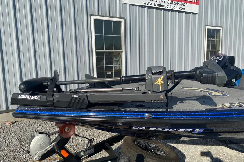 Slide: The Image of 2022 Phoenix 920 Elite boat with Lowrance Ghost trolling motor, parked outside a building. - 5