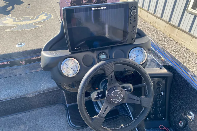 Slide: The Image of 2022 Phoenix 920 Elite boat dashboard with steering wheel and Humminbird Helix 12 display. - 8
