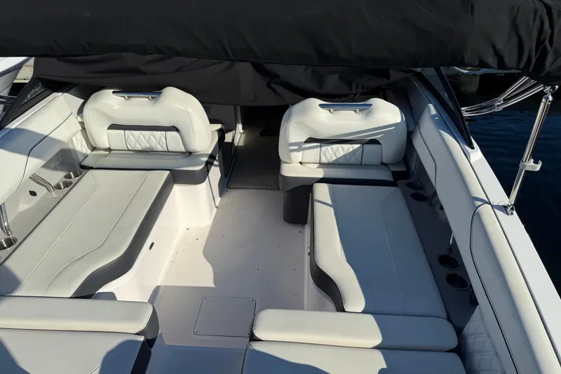 Slide: The Image of 2021 Regal LX2 boat interior with white leather seating and cup holders. - 6