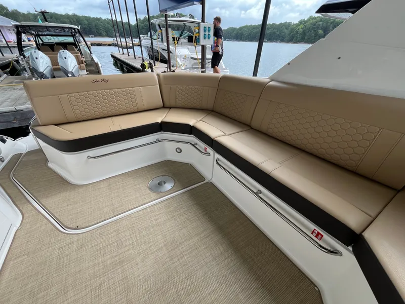 Slide: The Image of The image shows the cockpit of a Sea Ray Sundancer 320 with beige upholstery and a lake in the background. - 7