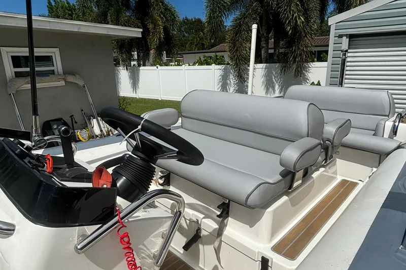 Slide: The Image of 2019 Williams Jet Tenders Dieseljet 505 with gray seating and steering wheel, parked outdoors. - 5