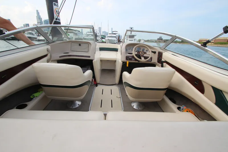 Slide: The Image of Interior of a 1999 Bryant 182 boat with beige seating and steering wheel. - 22