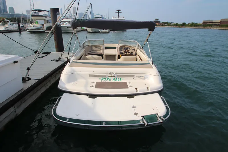 Slide: The Image of 1999 Bryant 182 boat docked at marina, rear view with canopy and open deck. - 25