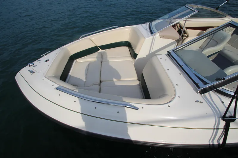 Slide: The Image of 1999 Bryant 182 boat with white seating, docked on calm water. - 5