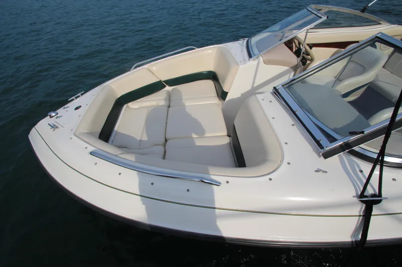 Slide: The Image of 1999 Bryant 182 boat with white seating, docked on calm water. - 6