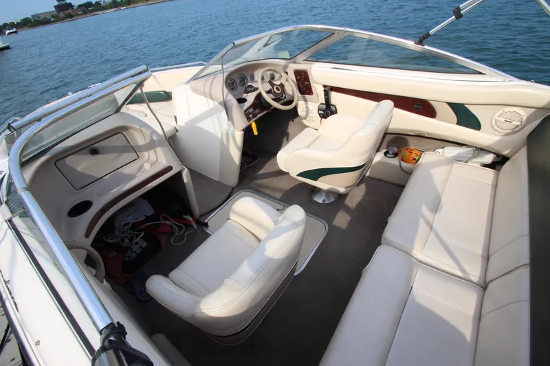 Slide: The Image of Interior of a 1999 Bryant 182 boat with white seating and steering wheel. - 7