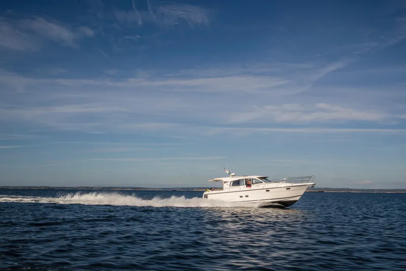 Slide: The Image of Nimbus 405 Coupé 2026 cruising on open water under a clear blue sky. - 2