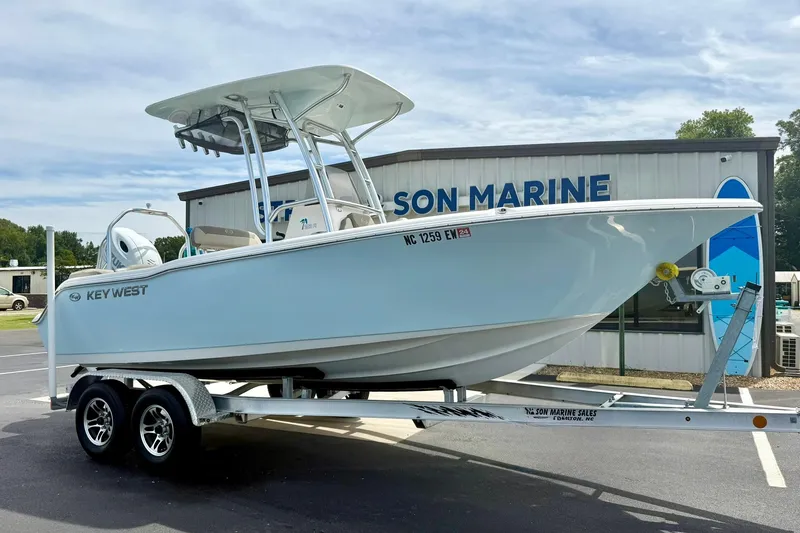 The Image of 2022 Key West 203 FS boat on trailer outside marine dealership. - 1