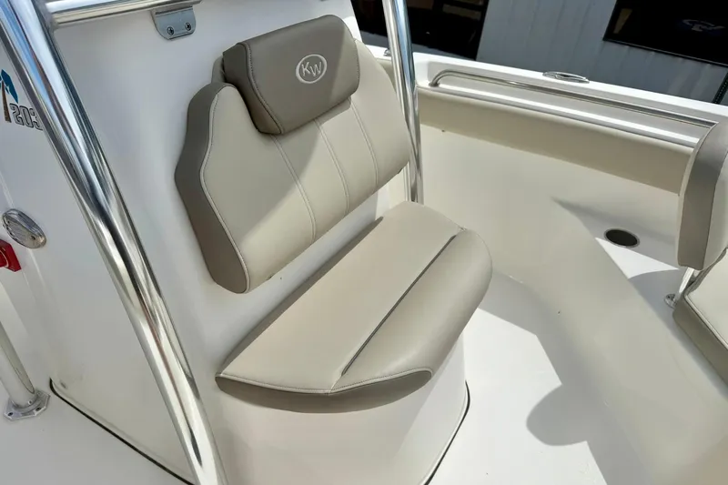 Slide: The Image of 2022 Key West 203 FS boat seat with beige upholstery and stainless steel frame. - 13