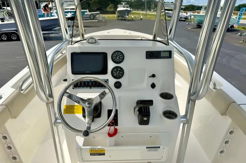 Slide: The Image of 2022 Key West 203 FS boat dashboard with steering wheel, gauges, and controls. - 17