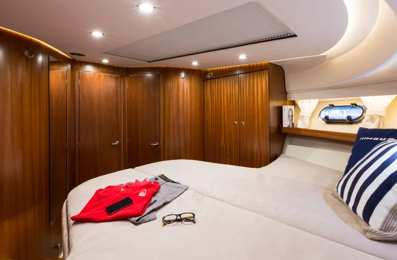 Slide: The Image of Luxurious cabin interior of 2025 Nimbus 405 Flybridge yacht with wood paneling and cozy bedding. - 11