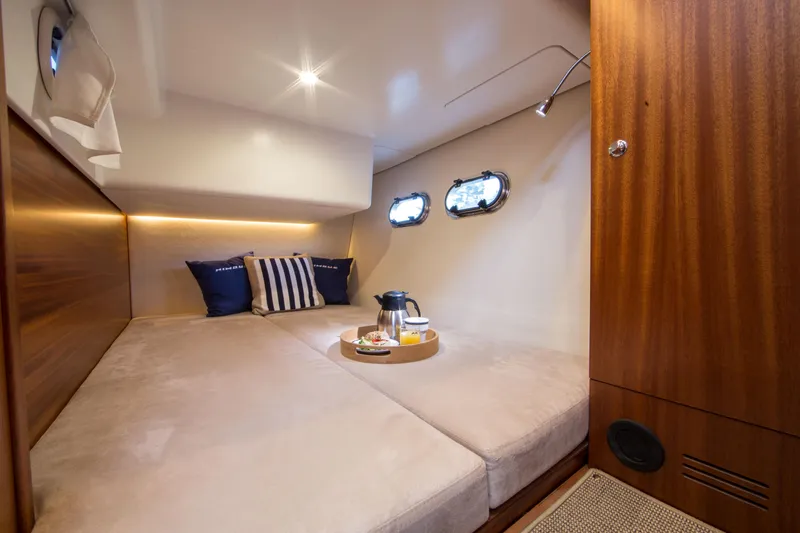 Slide: The Image of Luxurious cabin interior of 2025 Nimbus 405 Flybridge yacht with cozy bedding and porthole windows. - 13