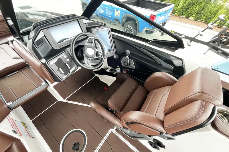 Slide: The Image of 2025 Supra SA450 boat interior with brown leather seats and modern dashboard controls. - 10