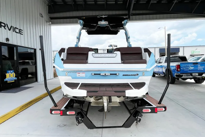 Slide: The Image of 2025 Supra SA450 boat on trailer at service center, rear view. - 3