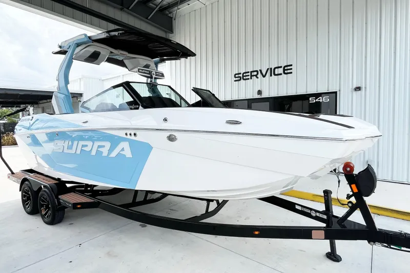 Slide: The Image of 2025 Supra SA450 boat on trailer outside service center. - 5