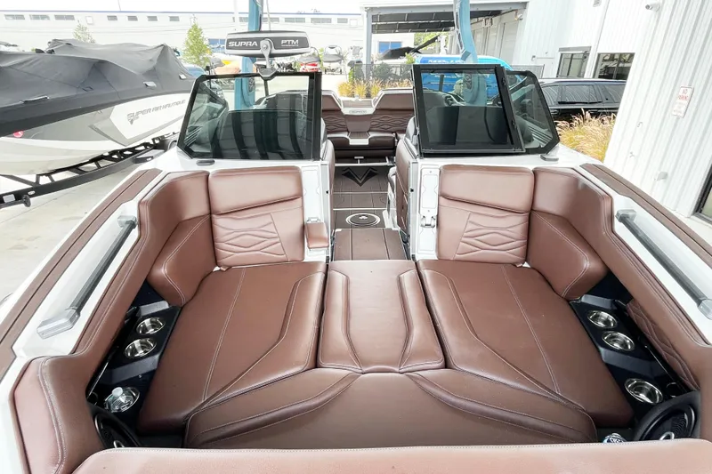 Slide: The Image of 2025 Supra SA450 boat interior with brown leather seating and cup holders. - 6