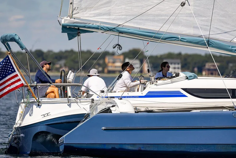 Slide: The Image of Sailing on a Dragonfly 32 Evolution trimaran, 2025 model, with American flag. - 21