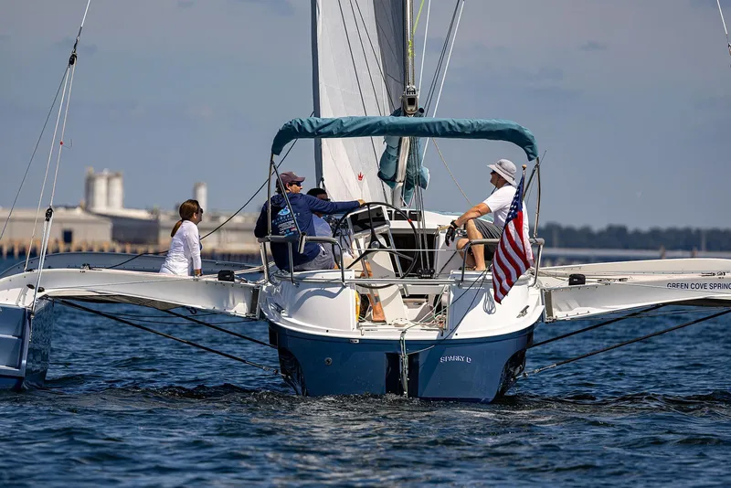 Slide: The Image of Sailing on a 2025 Dragonfly 32 Evolution trimaran with American flag, calm waters. - 28
