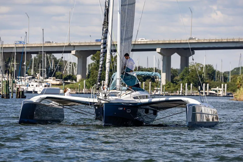 Slide: The Image of 2025 Dragonfly 32 Evolution trimaran sailing near a bridge on a sunny day. - 3