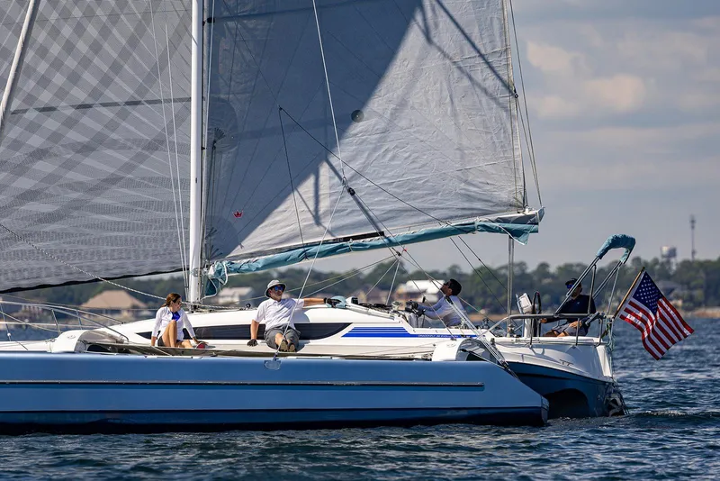 Slide: The Image of Sailing on a 2025 Dragonfly 32 Evolution trimaran with American flag in open waters. - 32