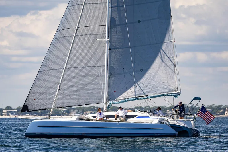 Slide: The Image of Sailing the 2025 Dragonfly 32 Evolution trimaran on a sunny day with an American flag. - 33