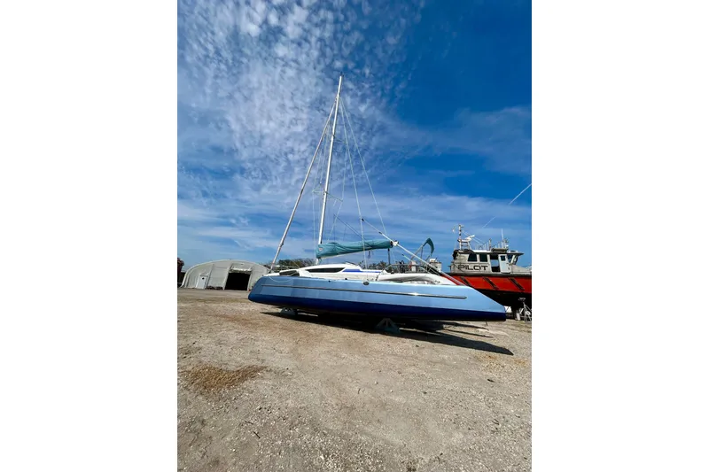 Slide: The Image of 2025 Dragonfly 32 Evolution sailboat on land under a clear blue sky. - 46