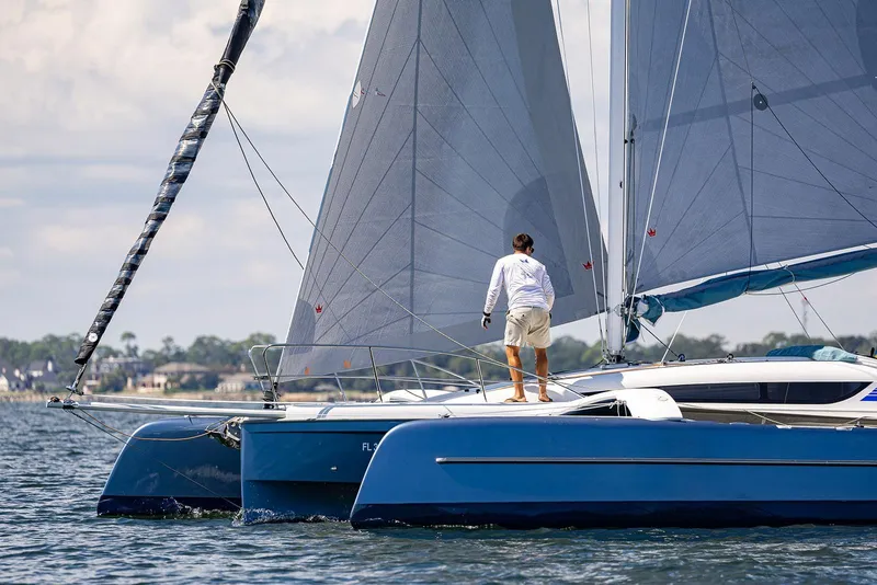 Slide: The Image of 2025 Dragonfly 32 Evolution sailboat on water with person standing on deck. - 8