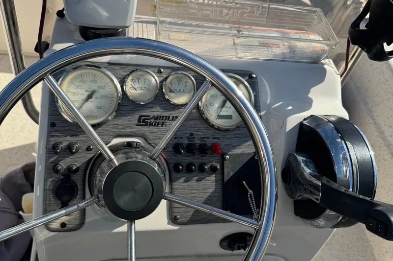 Slide: The Image of 2018 Carolina Skiff 16 JVX CC dashboard with steering wheel and gauges. - 2