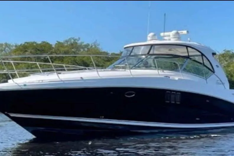 Slide: The Image of 2007 Sea Ray 440 Sundancer yacht on calm water, clear sky background. - 1