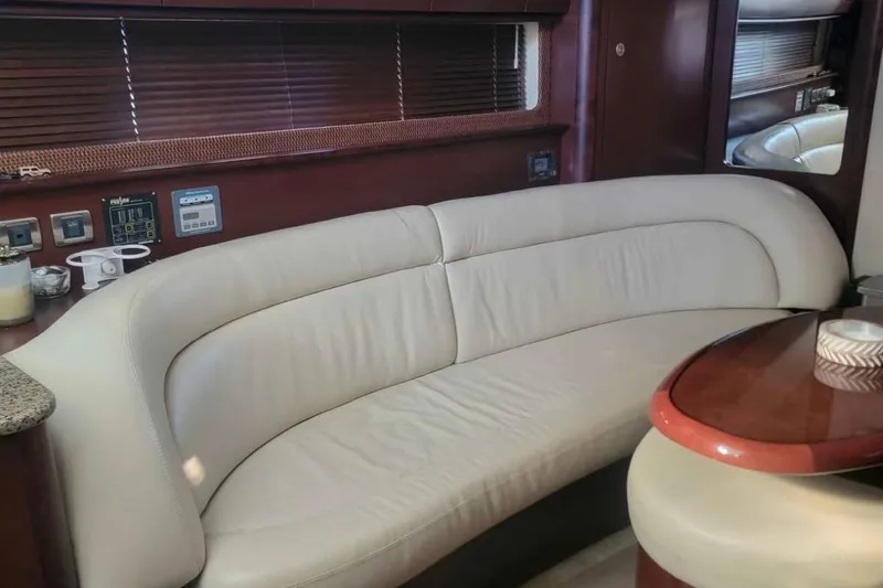 Slide: The Image of Luxurious interior of 2007 Sea Ray 440 Sundancer with cream leather seating and wooden accents. - 10
