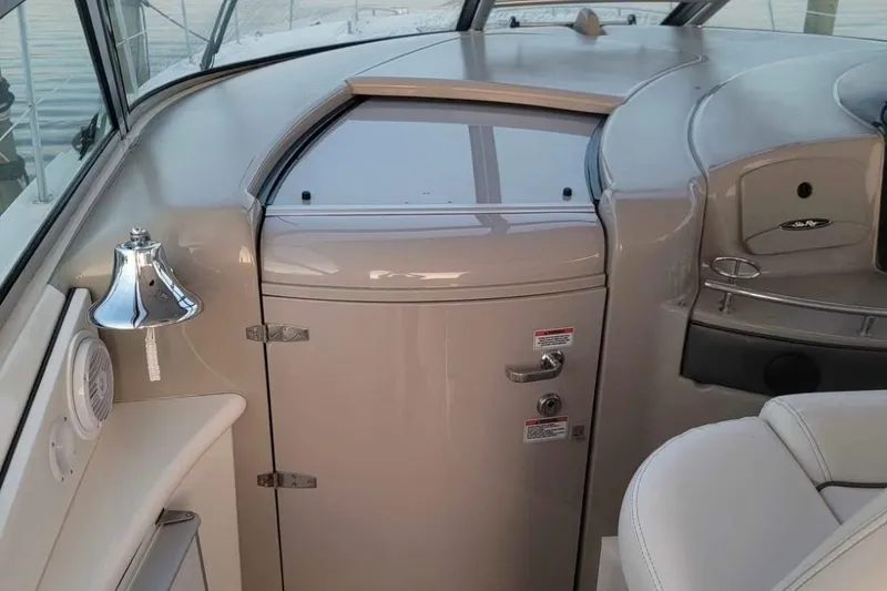 Slide: The Image of 2007 Sea Ray 440 Sundancer cockpit with helm, bell, and seating. - 2