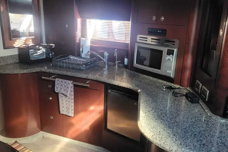 Slide: The Image of Luxurious 2007 Sea Ray 440 Sundancer yacht kitchen with modern appliances and granite countertops. - 9
