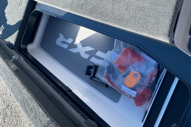 Slide: The Image of 2026 Skeeter FXR21 FLEX storage compartment with accessories and FXR branding. - 13