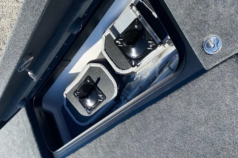 Slide: The Image of Storage compartment of 2026 Skeeter FXR21 FLEX boat, featuring secure latches and carpeted interior. - 19