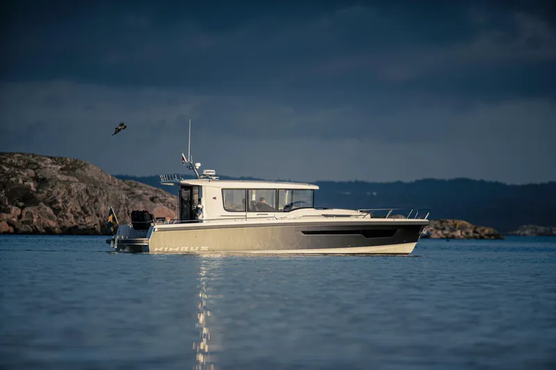 Slide: The Image of Nimbus Commuter 11 boat, 2026 model, cruising on calm waters under a cloudy sky. - 0