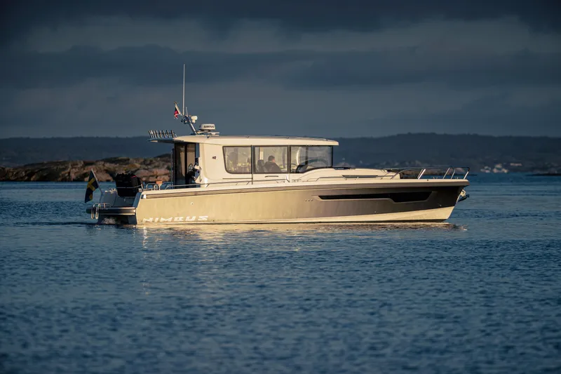 Slide: The Image of Nimbus Commuter 11 boat, 2026 model, cruising on calm waters under a cloudy sky. - 1