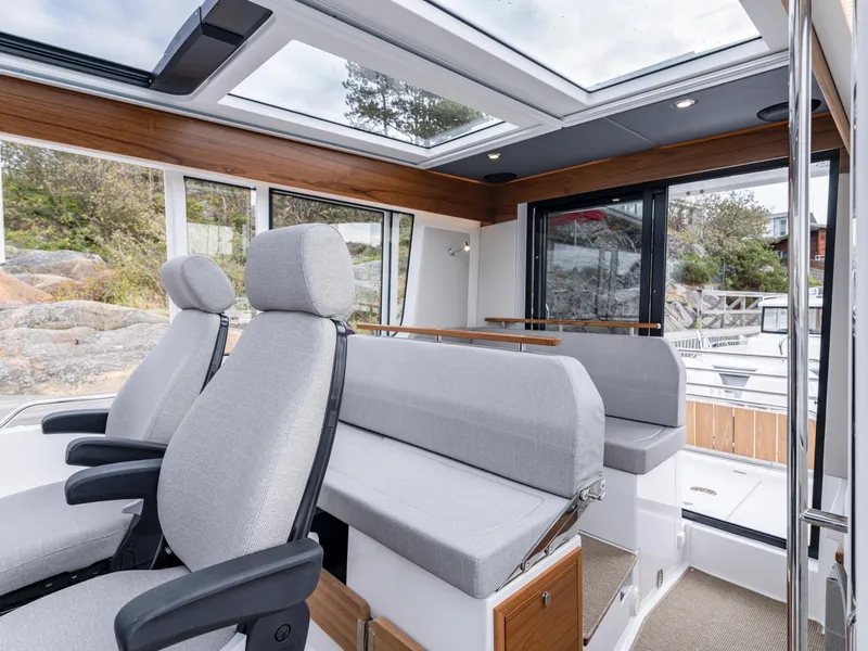 Slide: The Image of Interior of 2026 Nimbus Commuter 11 boat with modern seating and panoramic windows. - 22