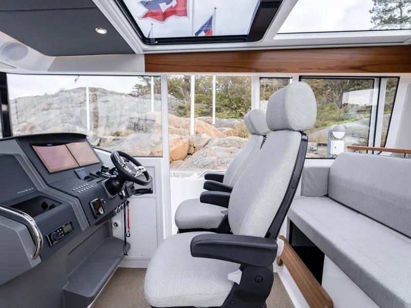 Slide: The Image of Interior of 2026 Nimbus Commuter 11 boat with modern seating and control panel. - 23