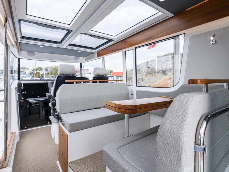 Slide: The Image of Interior of 2026 Nimbus Commuter 11 boat with modern seating and panoramic windows. - 29