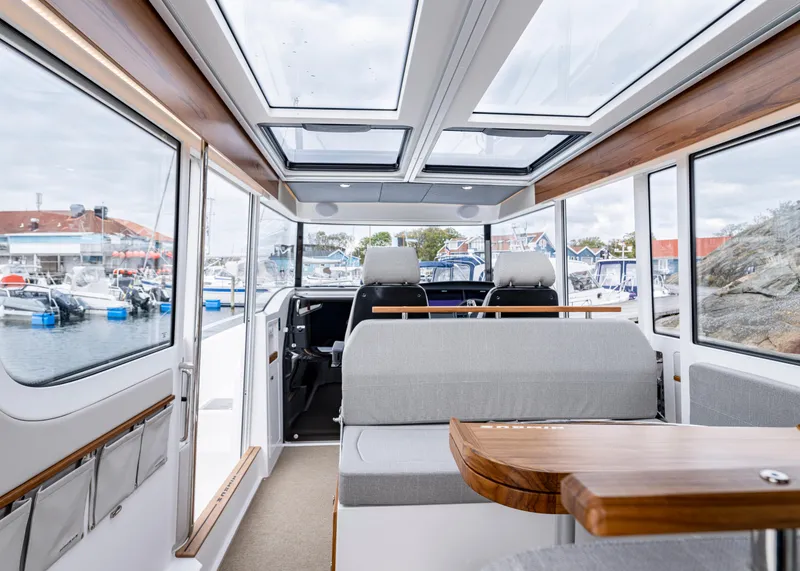 Slide: The Image of Interior of 2026 Nimbus Commuter 11 boat with panoramic windows and modern seating. - 32