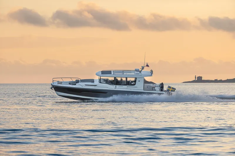 Slide: The Image of Nimbus Commuter 11 boat cruising at sunset, 2026 model, on calm waters. - 33