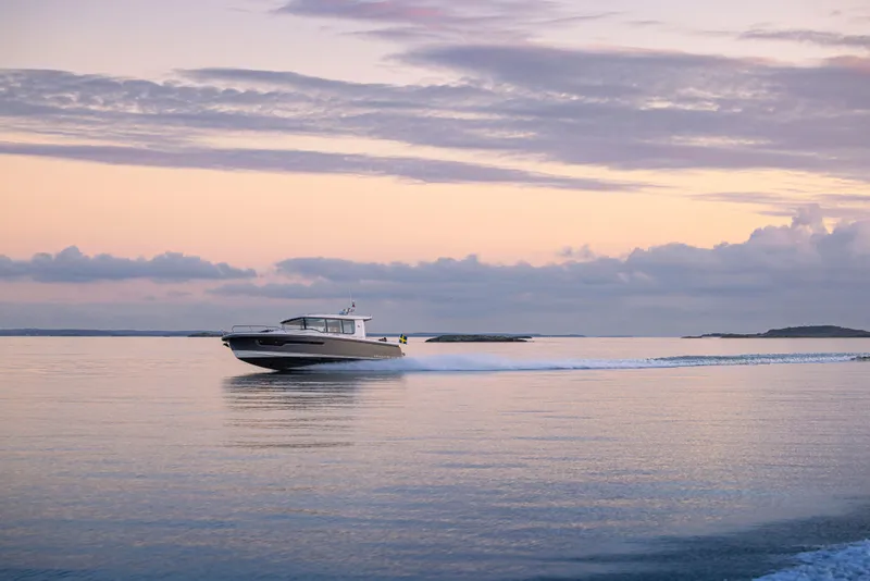 Slide: The Image of Nimbus Commuter 11 (2026) cruising on calm waters at sunset. - 37